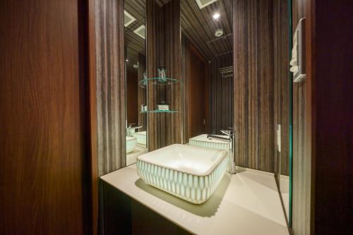 a bathroom with a white sink and a mirror at Beautemps in Osaka