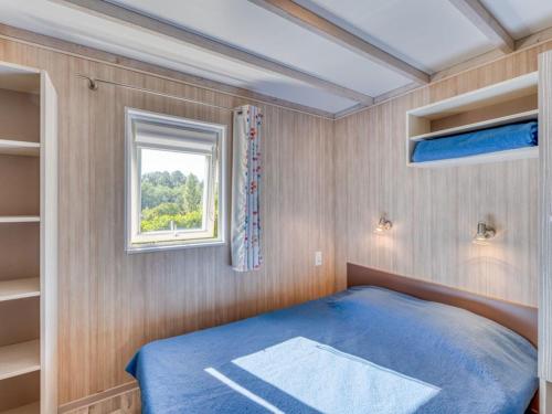 a small bedroom with a blue bed and a window at Cottage, animaux acceptés - 6 pers. - API-1-52-2931 in Lamonzie-Montastruc