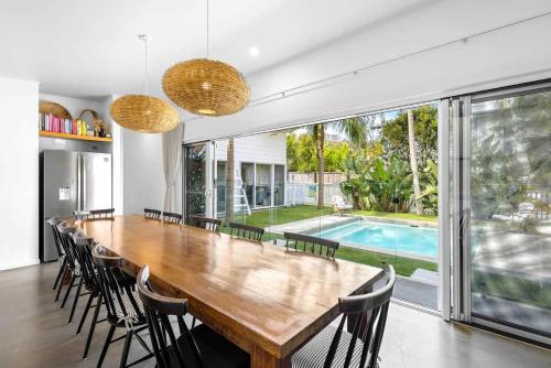 a large dining room with a large wooden table and chairs at Barra Luxe Beach House 4BR Yaroomba Beach Stay in Yaroomba