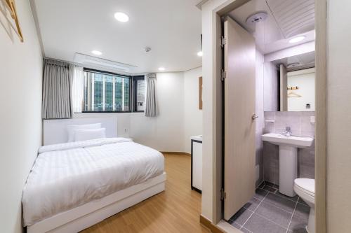 a bedroom with a bed and a sink and a toilet at Bliss Hotel Myeongdong in Seoul