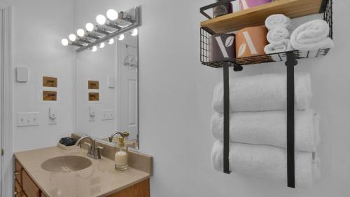 a bathroom with a sink and a shelf with towels at Waterfront, Hot Tub, Dock Kayaks, Movie Game Room in Lake Ariel