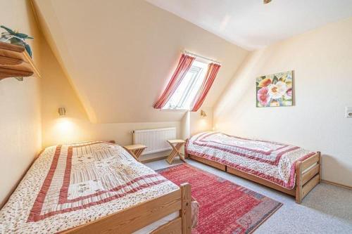 a bedroom with two beds and a window at Fewo-Inselblick in Nordstrand