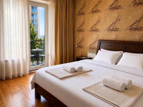 a bedroom with a large bed with towels on it at Villa Kobuleti in Kobuleti