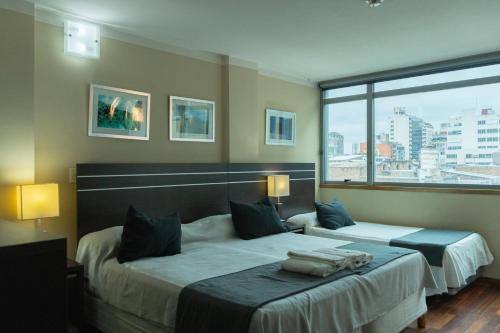 a hotel room with two beds and a large window at Zoom Apartments Hotel in Córdoba