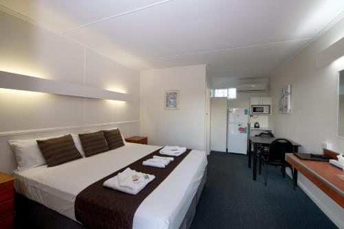 a hotel room with a bed and a desk at Mineral Sands Motel in Maryborough