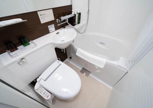 a bathroom with a white toilet and a sink at Super Hotel Premier Ginza in Tokyo
