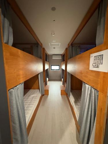an empty room with bunk beds and curtains at Hostel K wave Only Female Hongdae in Seoul