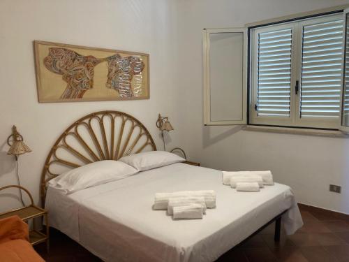 a bedroom with a bed with towels on it at Oasi Baia Verde in Baia Verde