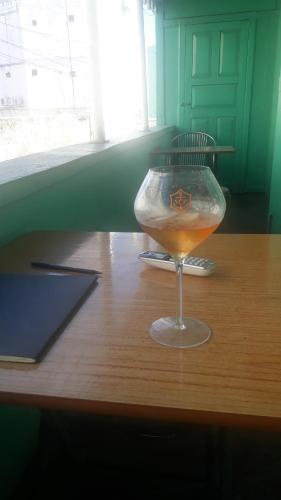 a wine glass sitting on top of a wooden table at Guest house in Basseterre