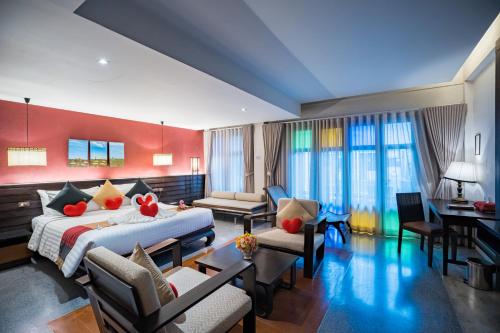 a hotel room with a bed and a living room at De Lanna Hotel in Chiang Mai