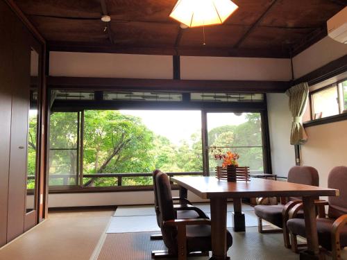 a dining room with a table and a large window at 丹徳庭園 in Kawagoe