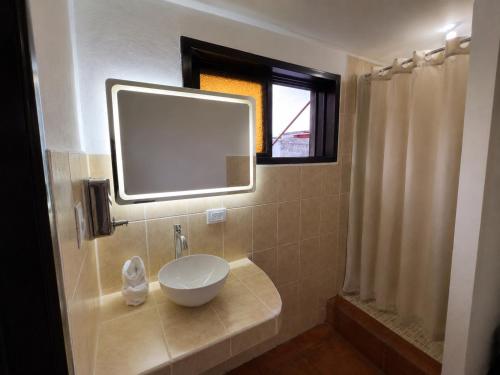 a bathroom with a sink and a mirror at Casa de la Torre in Antigua Guatemala