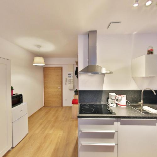 a kitchen with white cabinets and a counter top at Résidence les Cèdres in Strasbourg
