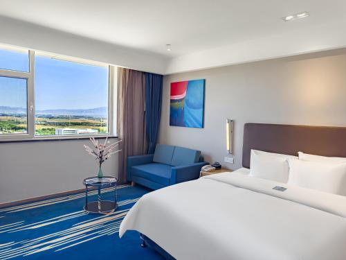 a hotel room with a bed and a window at Holiday Inn Express Zhangye by IHG in Zhangye