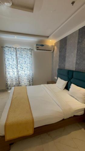 a bedroom with a large bed with a blue headboard at hotel shiv bliss inn Dibai in Dibai