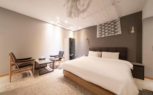 a bedroom with a bed and a table and chairs at HOTEL MYEONG JAK in Suwon