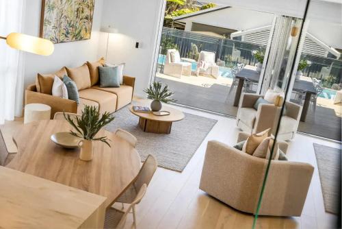 a living room with a couch and a table at Key West Beach House in Coolum Beach