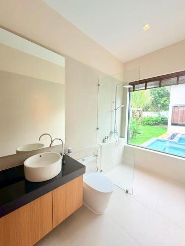 a bathroom with a sink and a toilet and a window at Bella Villa V1 in Koh Lone