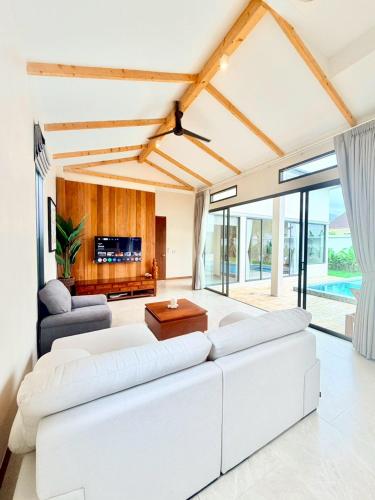 a living room with white furniture and large windows at Bella Villa V1 in Koh Lone