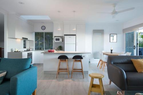 a kitchen and living room with a table and chairs at Villa Pandanus in Peregian Beach