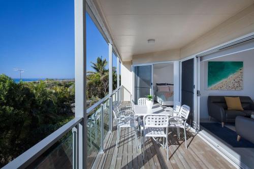 a balcony with a table and chairs and a couch at Villa Pandanus in Peregian Beach