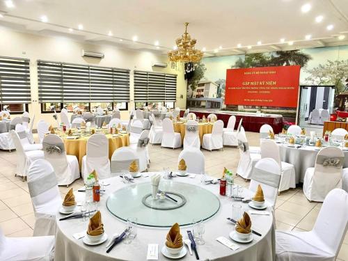 a banquet hall with white tables and white chairs at Nhà Khách TW in Hanoi