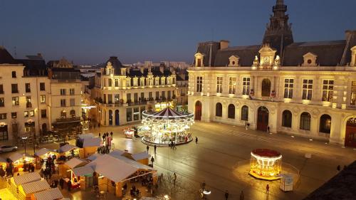 a city with a christmas market and a carousel at Hôtel Central in Poitiers