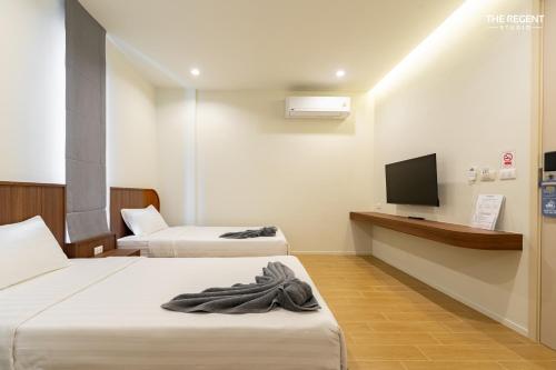 a hotel room with two beds and a flat screen tv at The Regent Studio Kamala in Kamala Beach