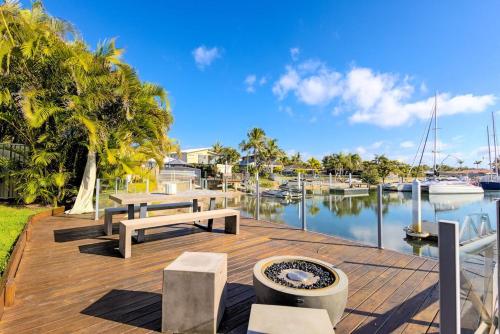 a wooden deck with benches and a body of water at Hampton Beach House on the Waterfront in Buddina
