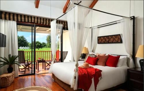 a bedroom with a white bed with red pillows at Laguna Fairway 3B villa-golf view in Laguna Phuket