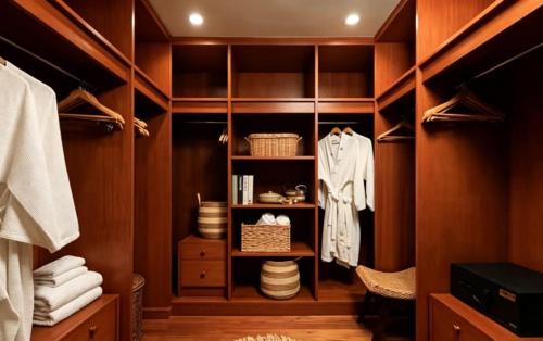 a walk in closet with wooden cabinets and clothes at Laguna Fairway 3B villa-golf view in Laguna Phuket