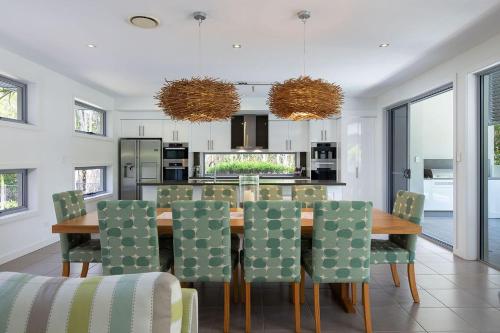 a kitchen and dining room with a table and chairs at Yaroomba Beach House in Yaroomba