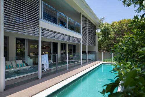 a house with a swimming pool in front of it at Yaroomba Beach House in Yaroomba
