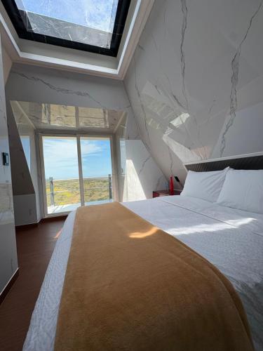 a bedroom with a large bed with a large window at Villas Safir en Valle de Gpe in Los Hornos