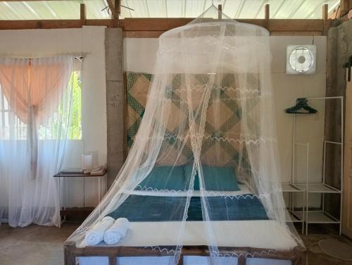a bedroom with a bed with a net at Kalma Kubo Siargao in San Isidro