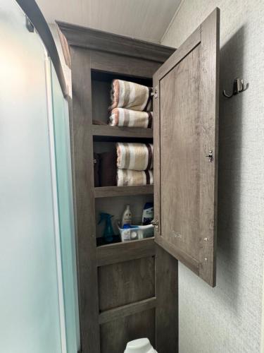 a wooden cabinet in a bathroom with towels at Waxberry Trailer by Kings Canyon and Sequoia National Parks in Squaw Valley