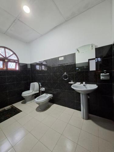 a bathroom with two toilets and a sink at Royal Mount Hotel in Pussellawa