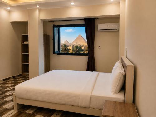 a bedroom with a bed with a view of the pyramids at Pyramids Front Gate Hotel in Cairo