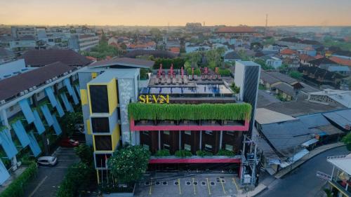 a building with a green roof in a city at Sevn Legian in Legian