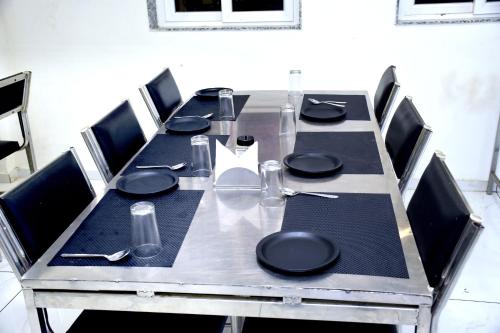 a long table with chairs and a table set for a meal at Infinity Hotel in Rajkot