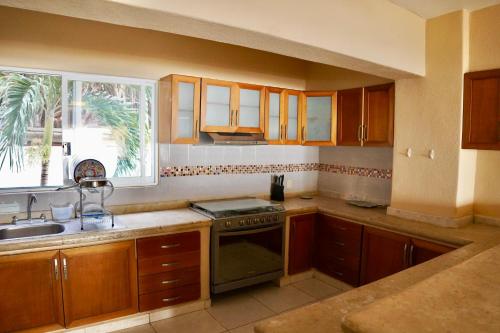 a kitchen with a stove and a sink and a window at Rincon Frente al mar in Acapulco