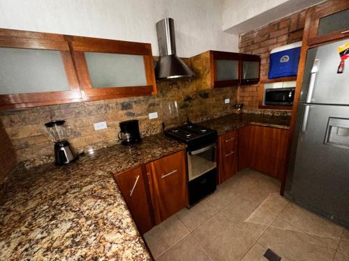 a kitchen with wooden cabinets and a granite counter top at Hostal White beach in Paraguchi