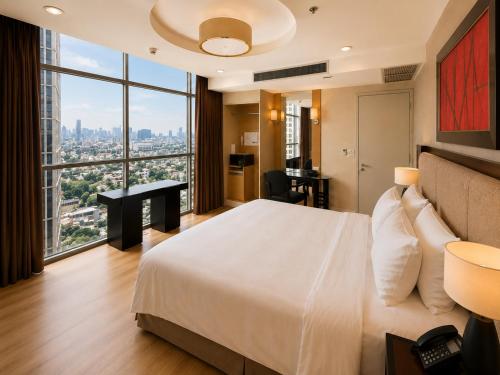 a bedroom with a large white bed and a desk at Urbana Sathorn Hotel, Bangkok in Bangkok