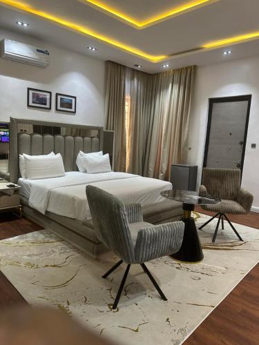 a bedroom with a bed and a table and chairs at DOD Residence I Cozy 3BR with Fast Wifi in Ikuata
