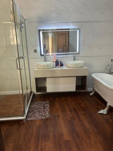a bathroom with two sinks and a tub and a mirror at DOD Residence I Cozy 3BR with Fast Wifi in Ikuata