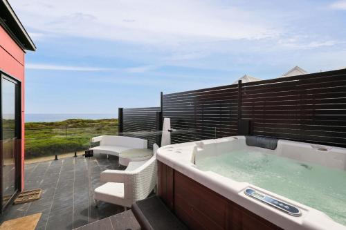 a bath tub sitting on top of a balcony at Amazing Ocean Views with Spa in Surf Beach
