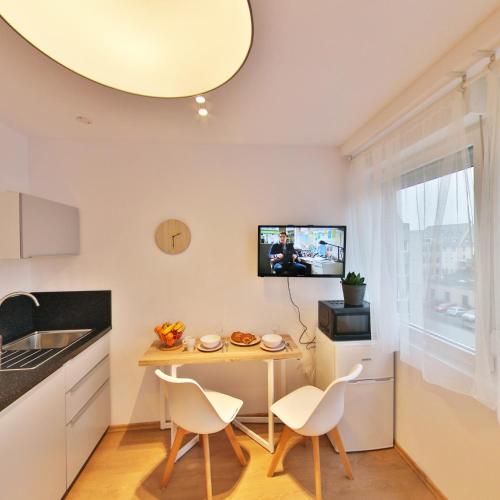 a small kitchen with a small table and chairs at Résidence les Cèdres in Strasbourg