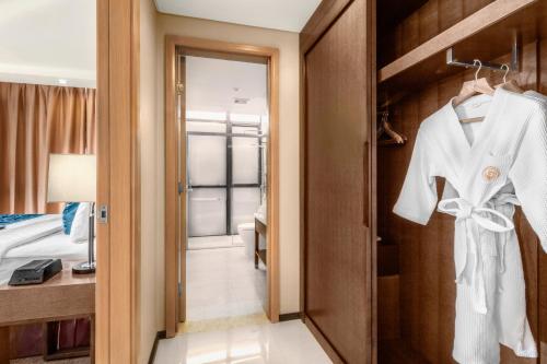 a hotel room with a white robe on a door at Golden Phoenix Hotel - Manila in Manila