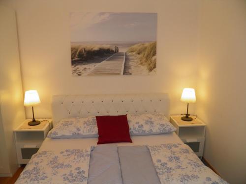 een slaapkamer met een bed met twee nachtkastjes en twee lampen bij Apartments Perla in Dinjiška