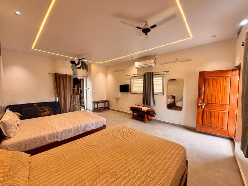 a bedroom with two beds and a ceiling fan at Rajkamal Hampi in Hampi